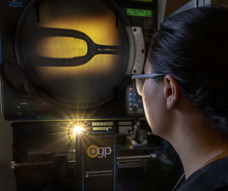 Un membre de l'équipe Miltec inspecte une ampoule à l'aide d'un équipement dans notre laboratoire de batteries.